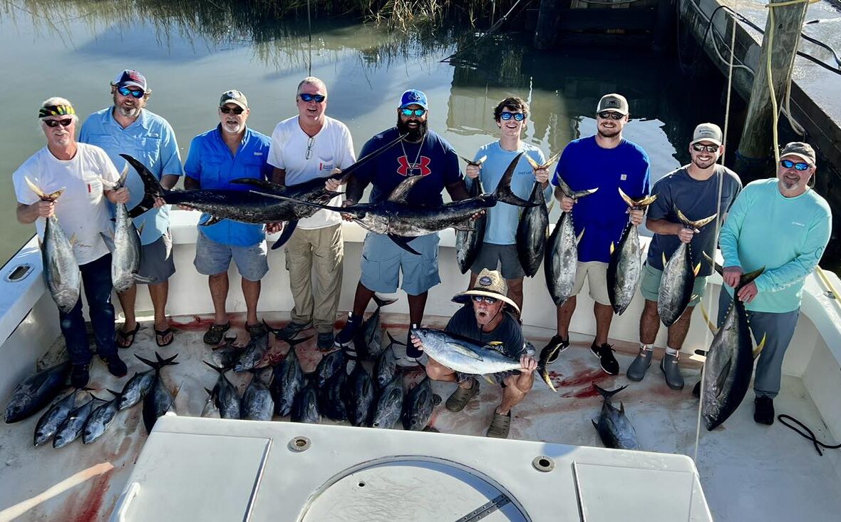 group of fishermen showing off their catch to the camera