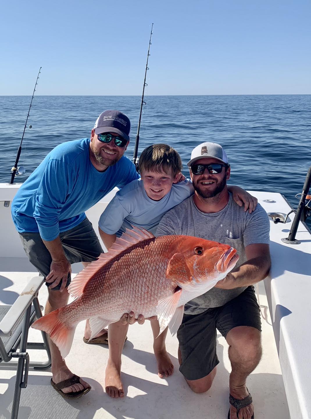 Father and son hold a Red Snapper